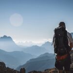 Abenteuerlustiger Wanderer mit Rucksack in den Bergen bei Sonnenaufgang, ultimatives outdoor Erlebnis, Natur, Bergsteigen, Wandern, Freedom, Naturerlebnis, Landschaft, Trail, Entdeckung, Naturfotografie.